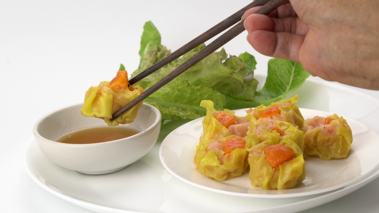 挑选一份新鲜美味的自制虾仁、肉末、咸蛋黄白瓷盘蒸饺。视频下载