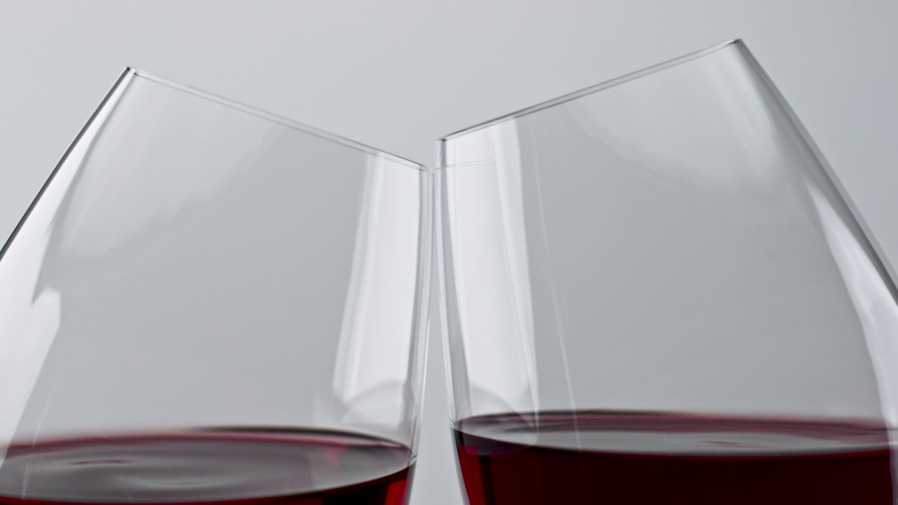 酒精，红色饮料，碰杯特写。欢快的玫瑰酒清澈的玻璃杯视频下载