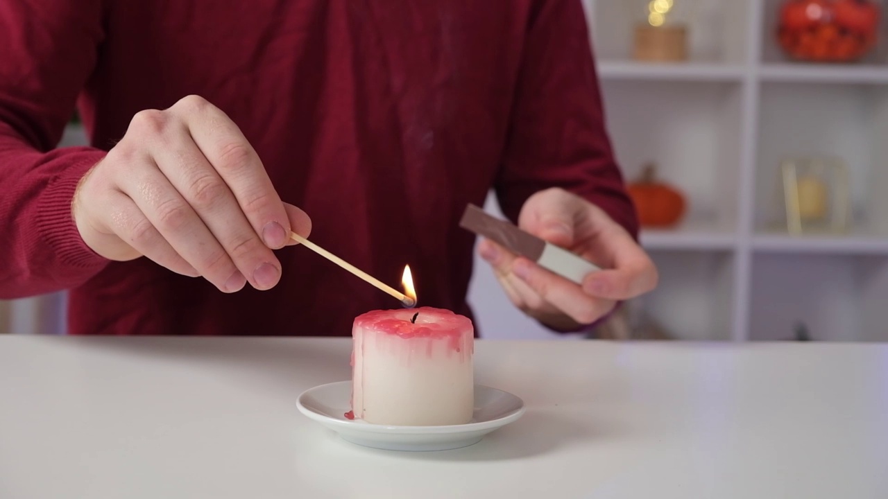 Diy万圣节万圣节白色蜡烛，覆盖在红色蜡像血滴在白色背景。视频素材