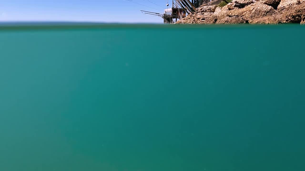 水下的trabocco或trabucco在蓬塔Penna海滩在Costa dei Trabocchi, Abruzzo在意大利。低角度慢动作水面边缘视图视频素材