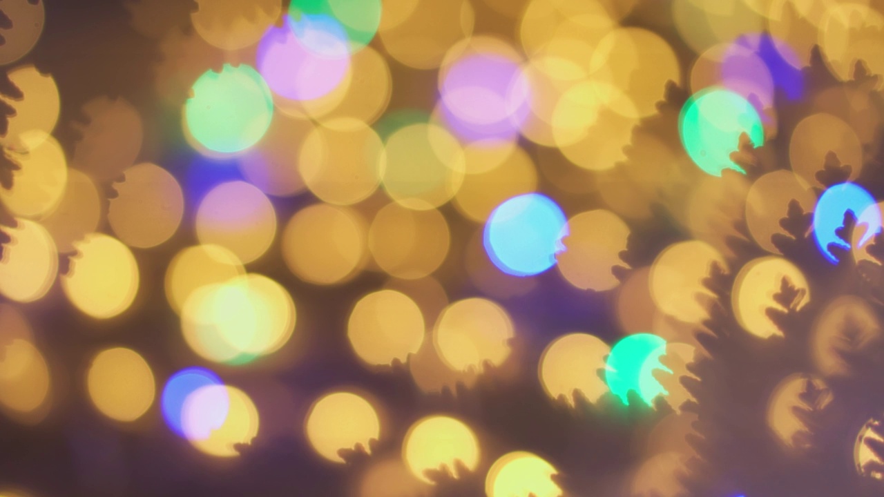 圣诞树的散景背景。模糊的童话新年之光。闪闪发光的抽象彩色圆圈使节日彩灯散焦。没有重点的装饰，主题和概念冬季背景。视频素材