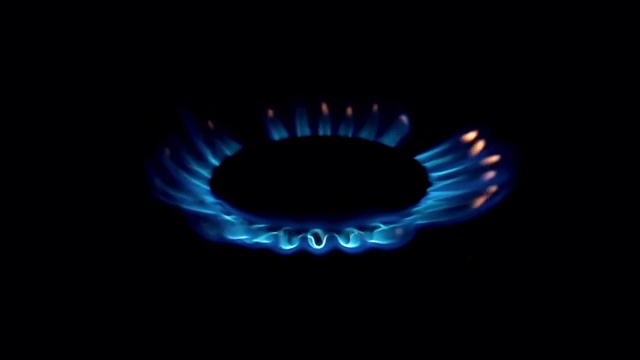 慢动作点亮了煤气炉顶部的蓝色气体，在黑色背景上。视频下载
