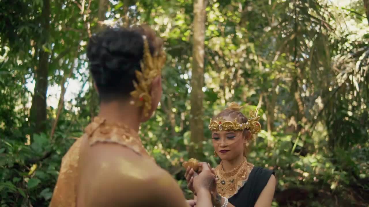 一个男人在和女友调情时，送给她一朵从绿色森林中摘来的金花视频素材