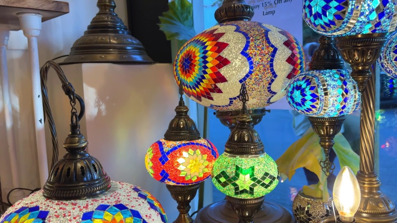 鲜艳的多色土耳其灯挂在商店里，在不同的颜色闪烁着马赛克彩色的星星和花画在灯本身，他们看起来像一个光球视频素材