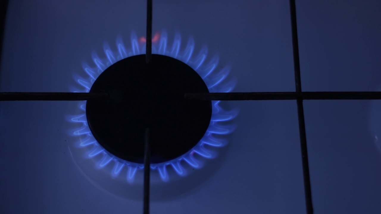 蓝色的火焰在炉子的燃烧器里燃烧煤气。视频素材
