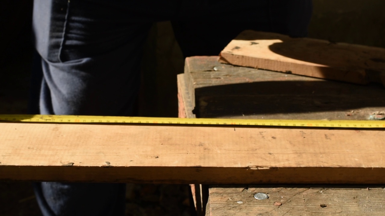 木匠在木板上测量所需的尺寸。视频下载