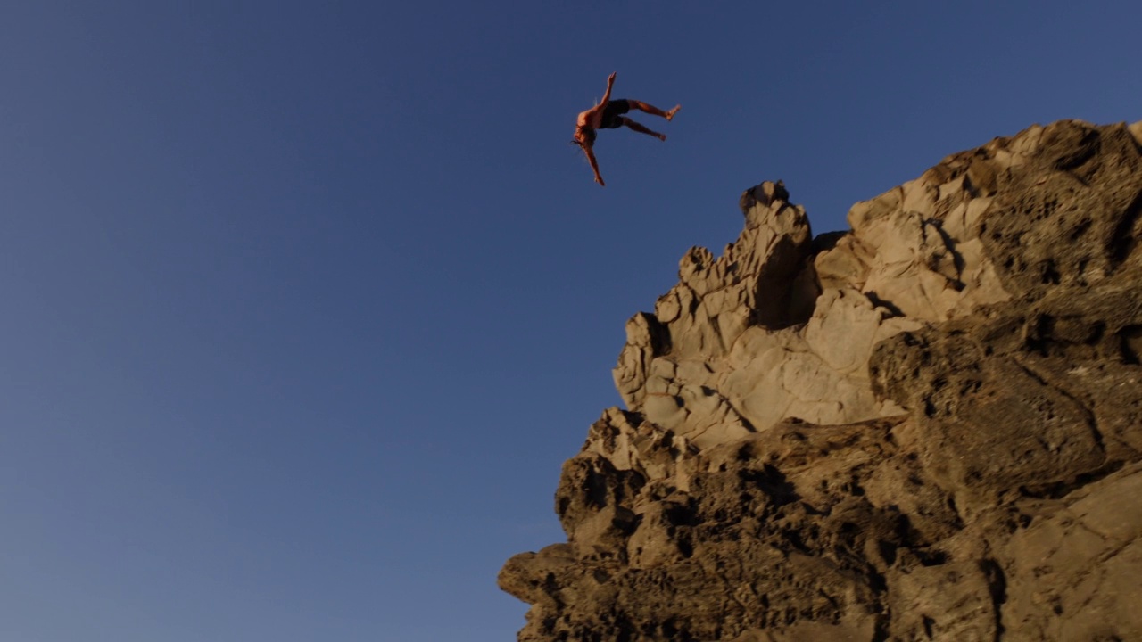 年轻人极限跳崖后空翻入海视频素材