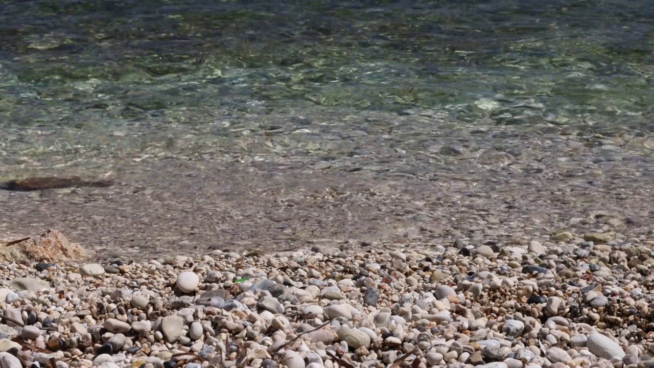 海浪特写。海浪拍打着海滩上的鹅卵石。暑假的概念。视频下载