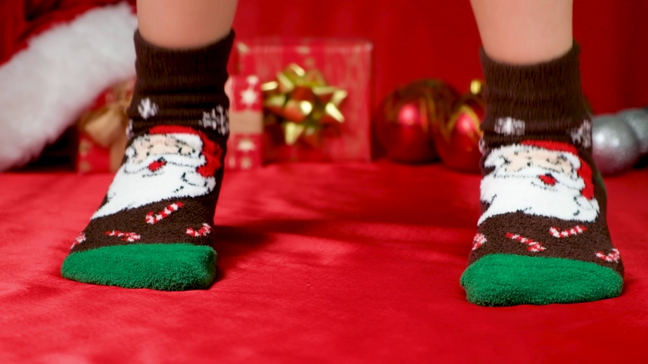 有趣的圣诞腿在温暖的毛边袜跳起来。视频下载