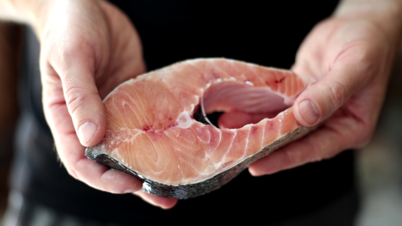 用新鲜的鲑鱼片在手中。健康的好处视频下载