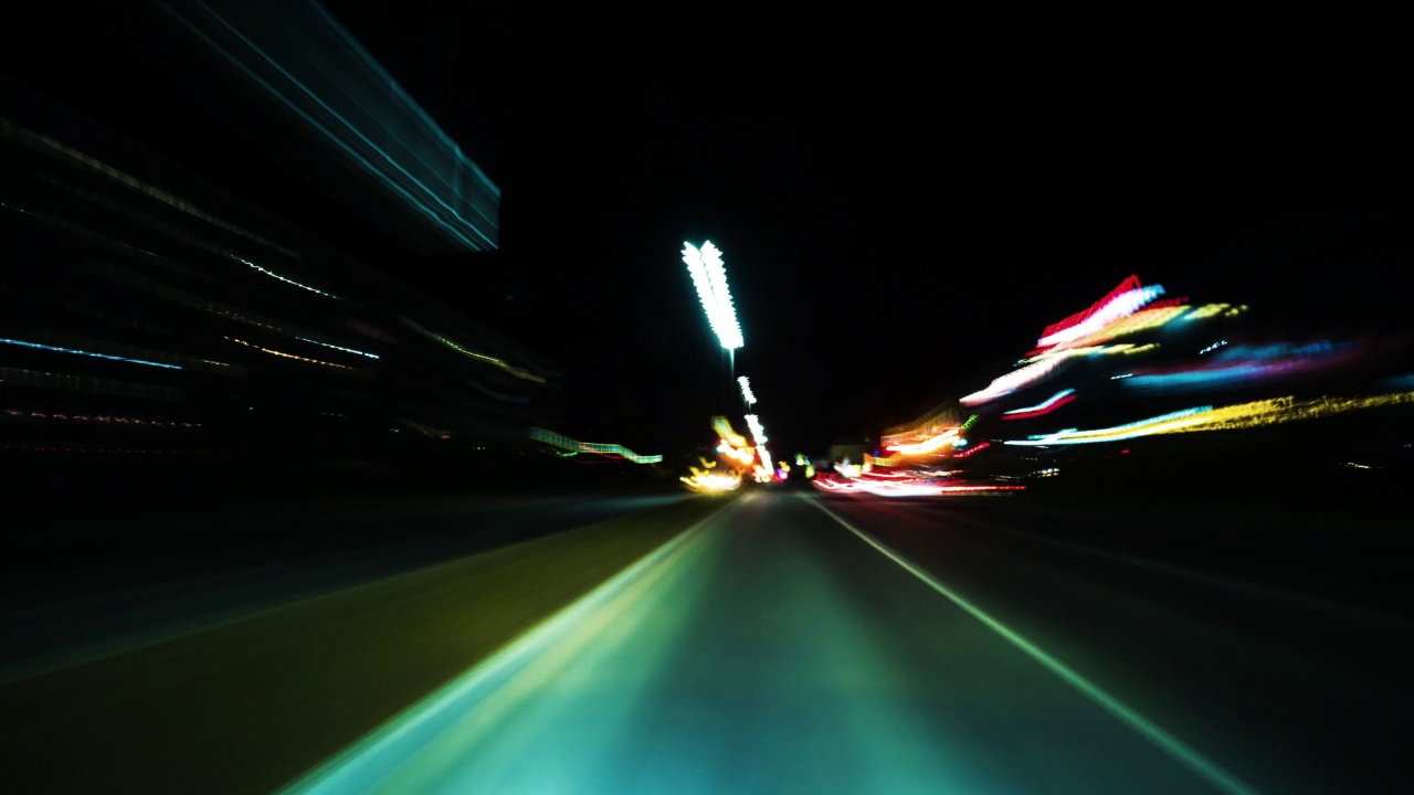 明亮的运动时间流逝的一个快速夜间驾驶在一个大城市，挡风玻璃的看法。视频素材