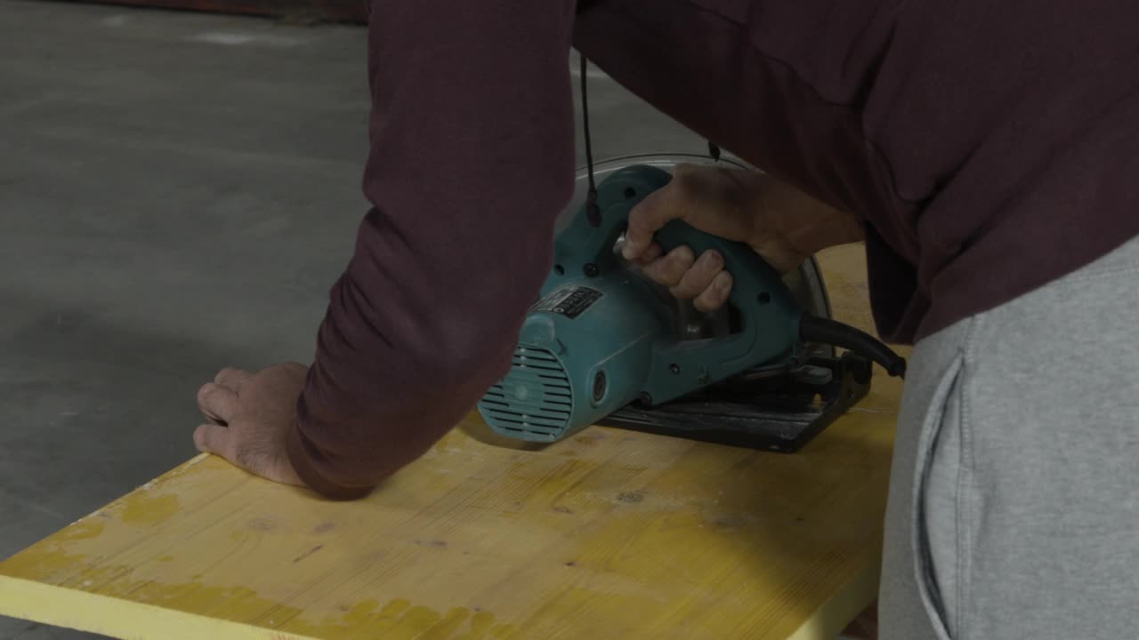 男子用电锯切割木板视频下载