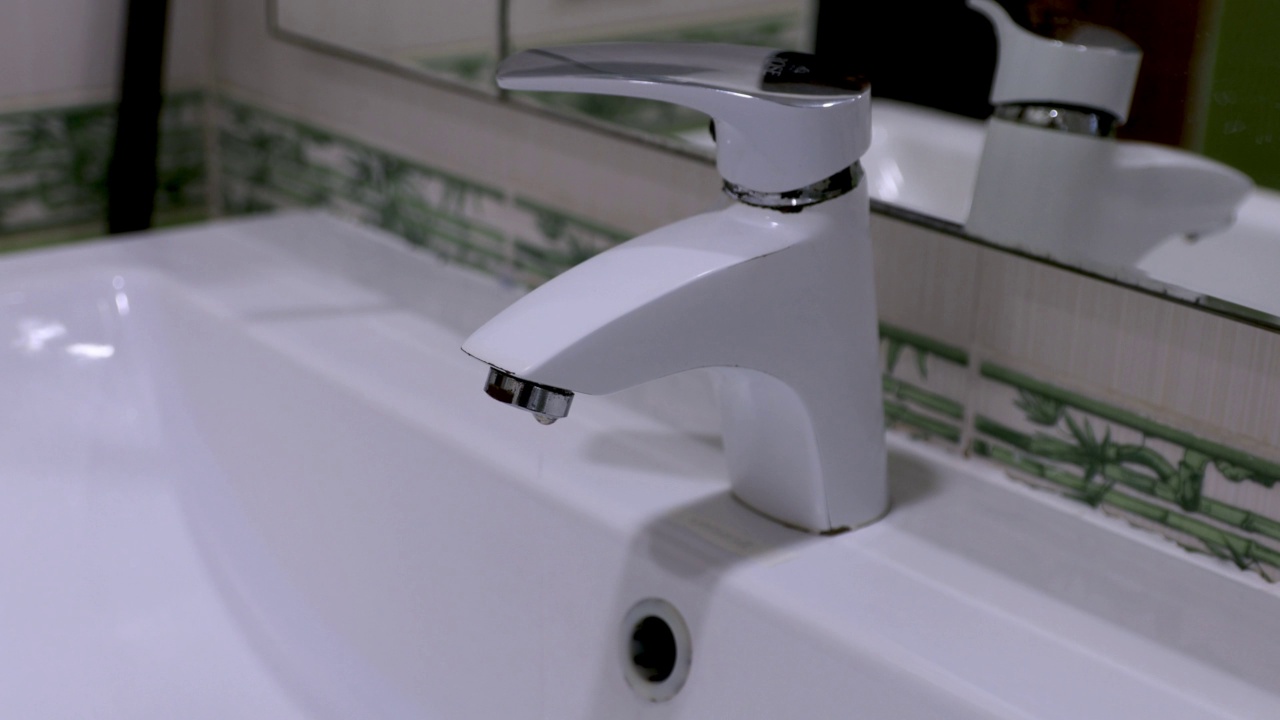 浴室。白色的水龙头在滴水。漏水的概念。视频素材