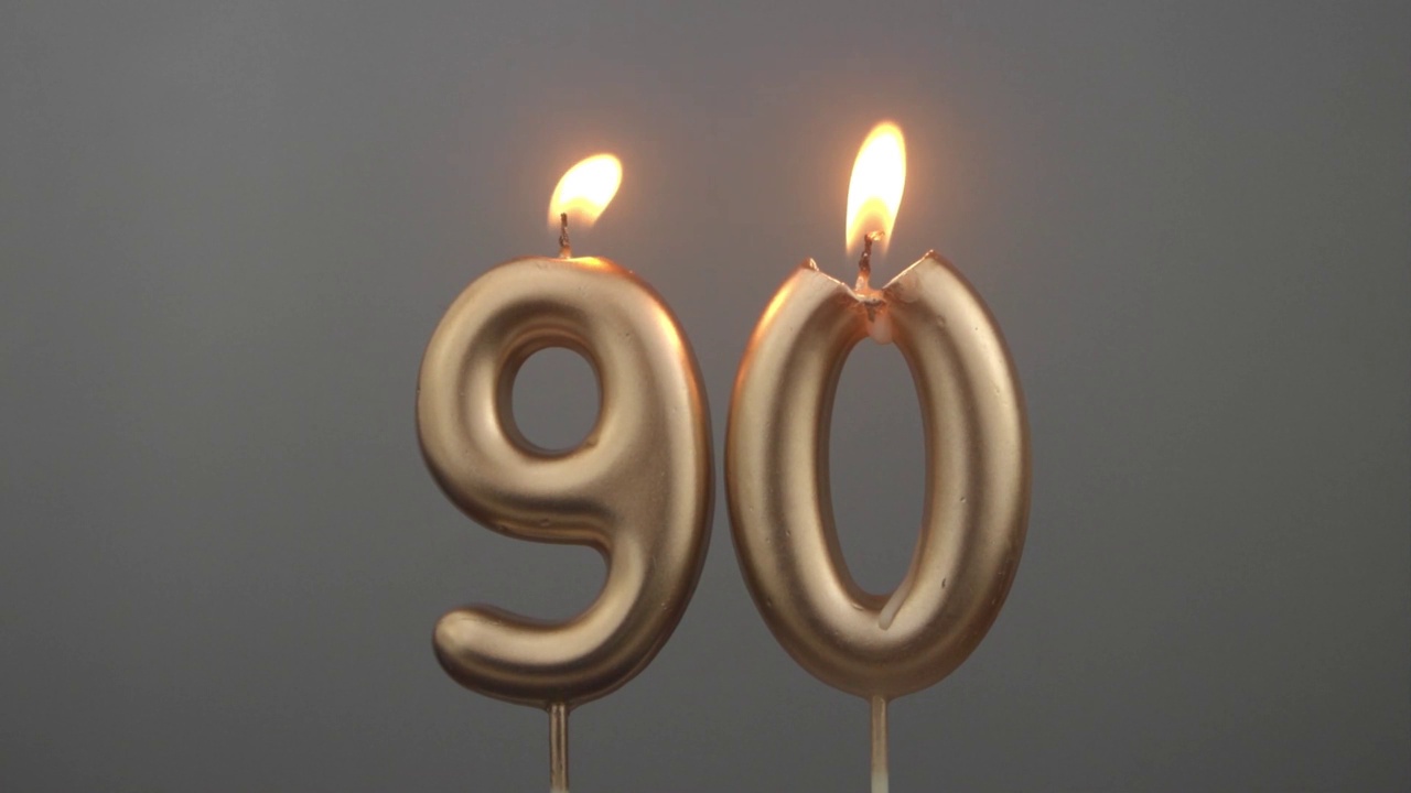 灰色背景下燃烧的金色生日蜡烛，90号视频下载