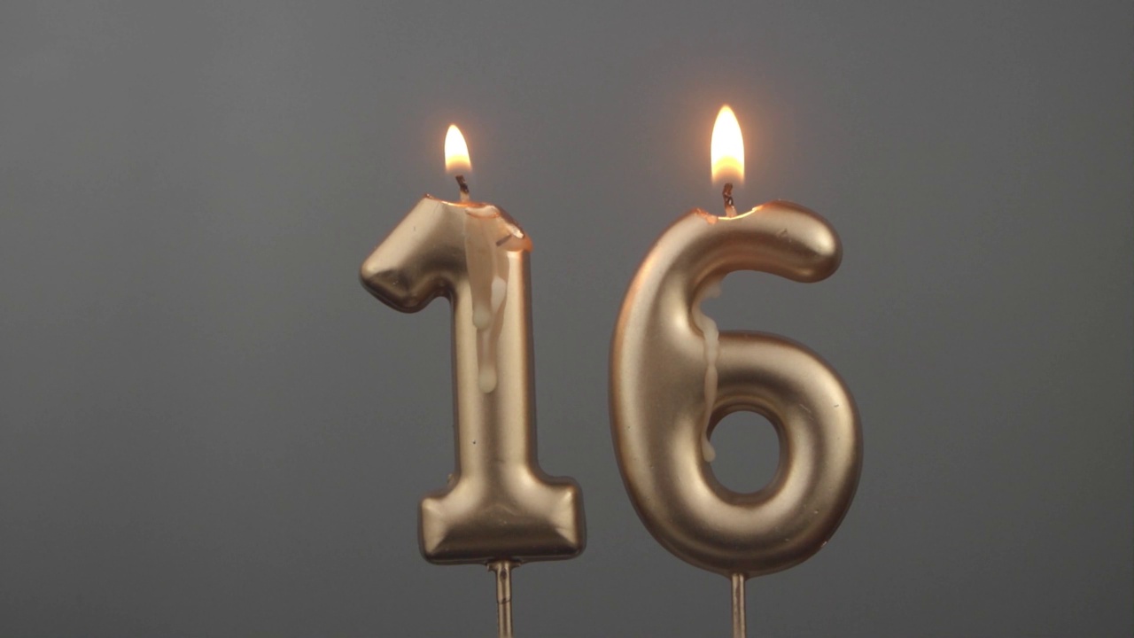 灰色背景下燃烧的金色生日蜡烛，16号视频下载