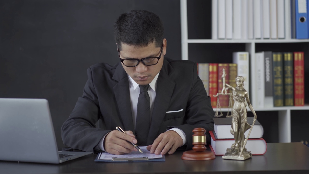 亚洲男性律师工作与锤子笔记本电脑正义女神在律师事务所，在线咨询的概念。视频下载