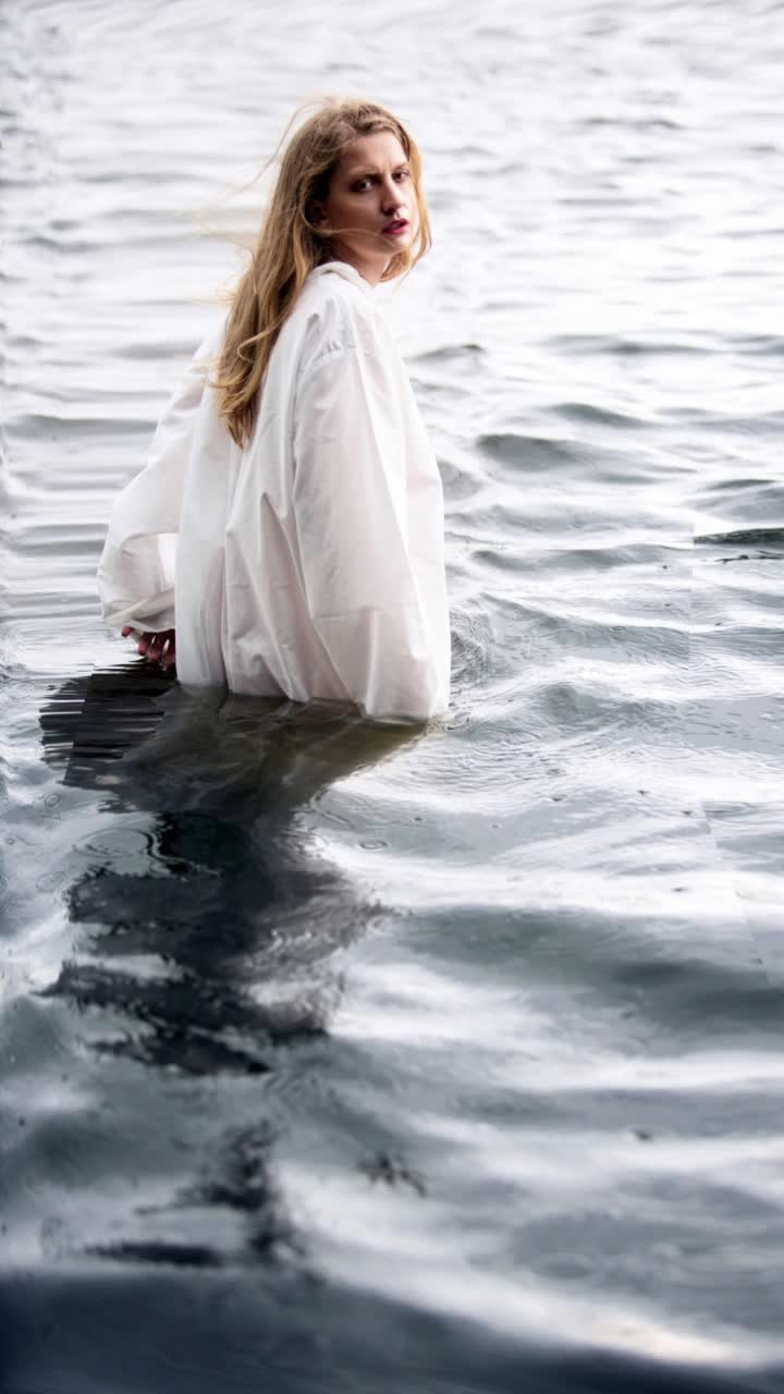 电影镜头的女人在白色的裙子站在水里视频下载