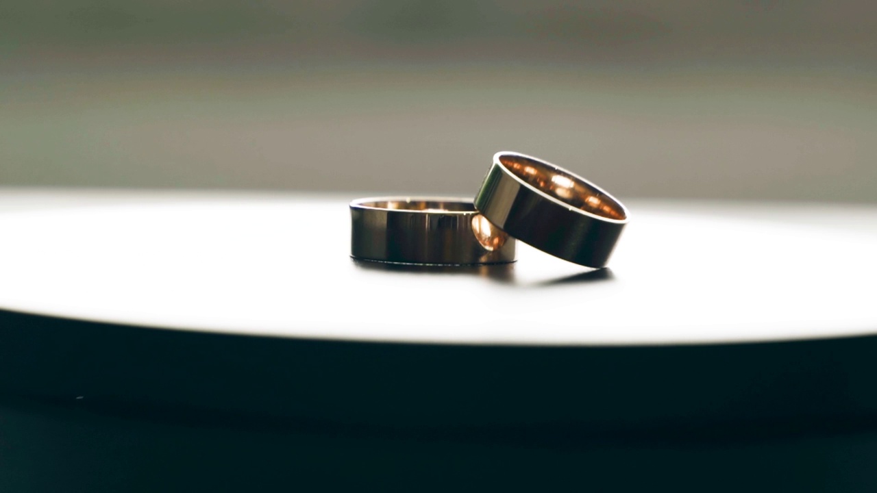 两枚结婚金戒指在桌上旋转视频素材