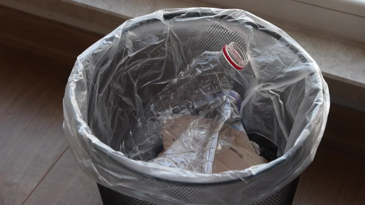 用手将瓶子放入回收箱视频素材
