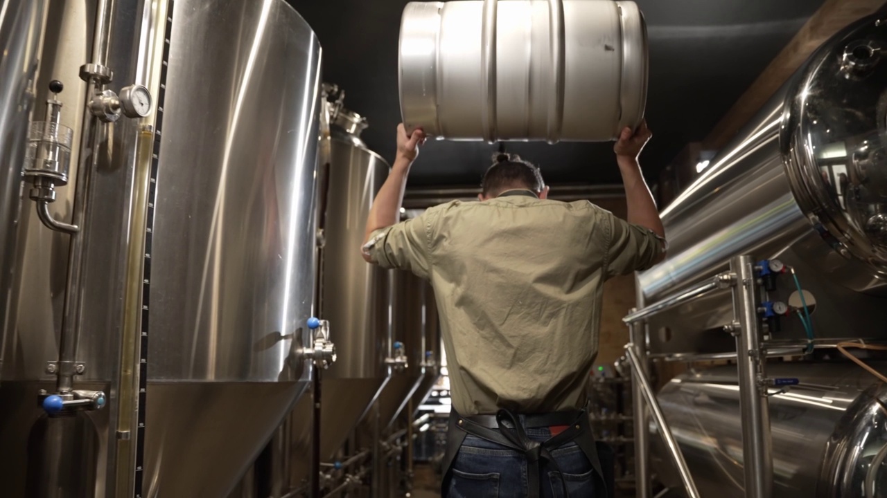 在现代啤酒厂里，酿酒师手里拿着一个金属桶视频下载