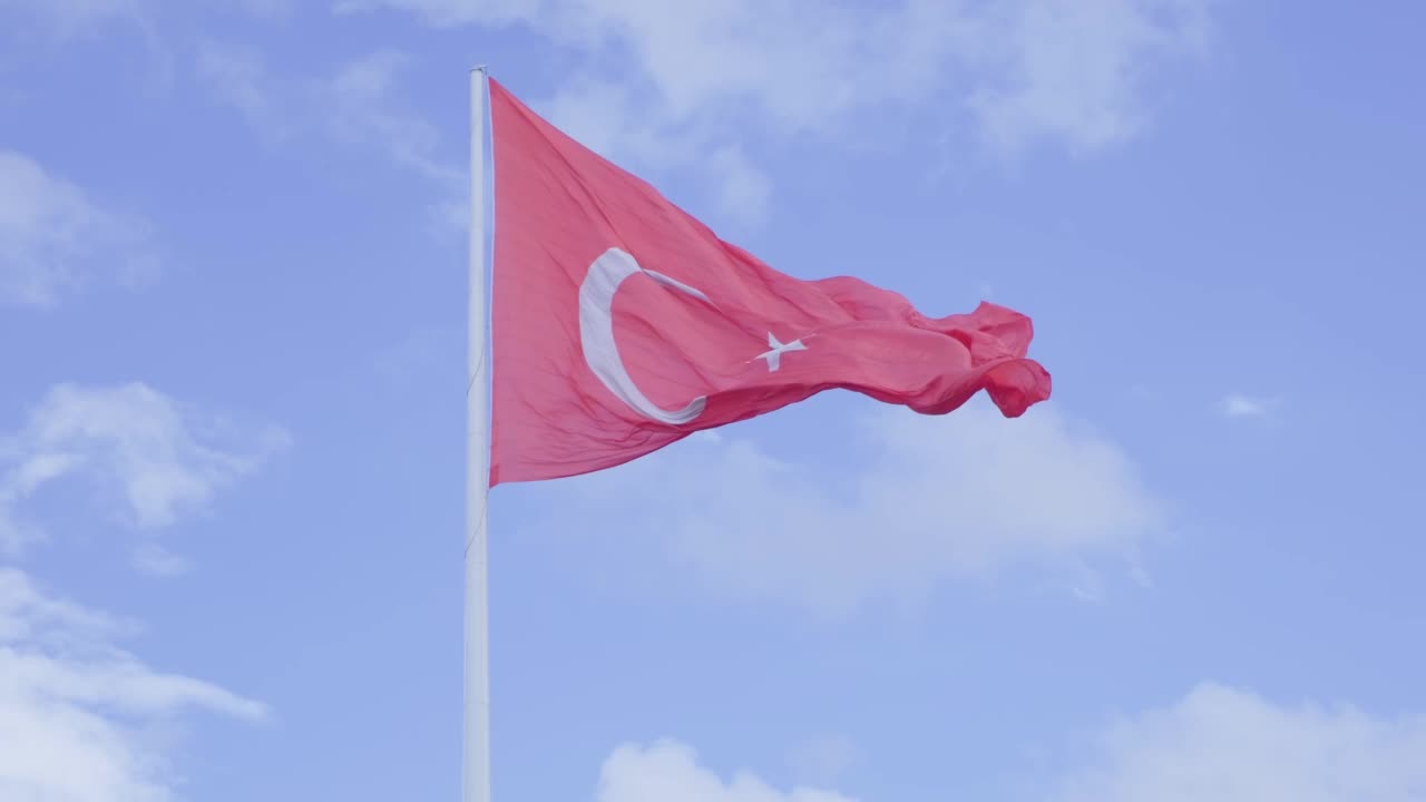 土耳其国旗在蓝天背景下的慢镜头。视频素材