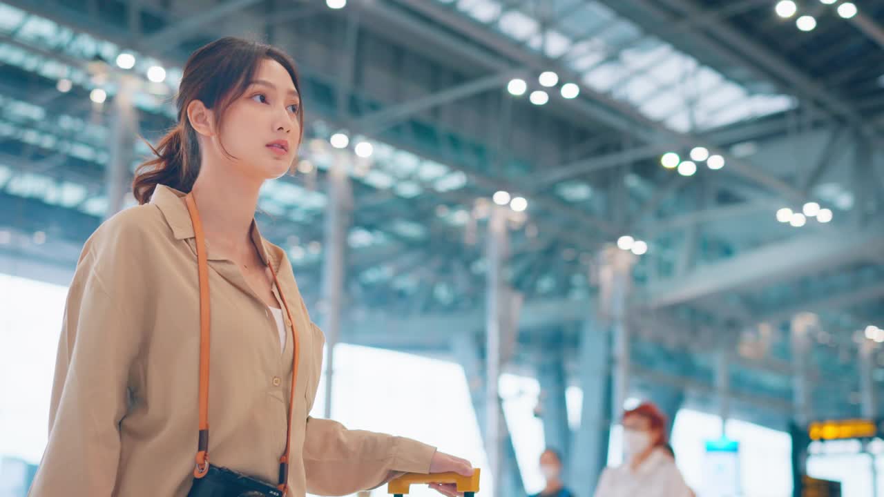 亚洲女性旅客在机场候机楼查看航班时刻表。旅游旅行概念视频素材