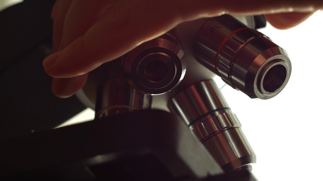 科学家转动显微镜镜头。视频下载
