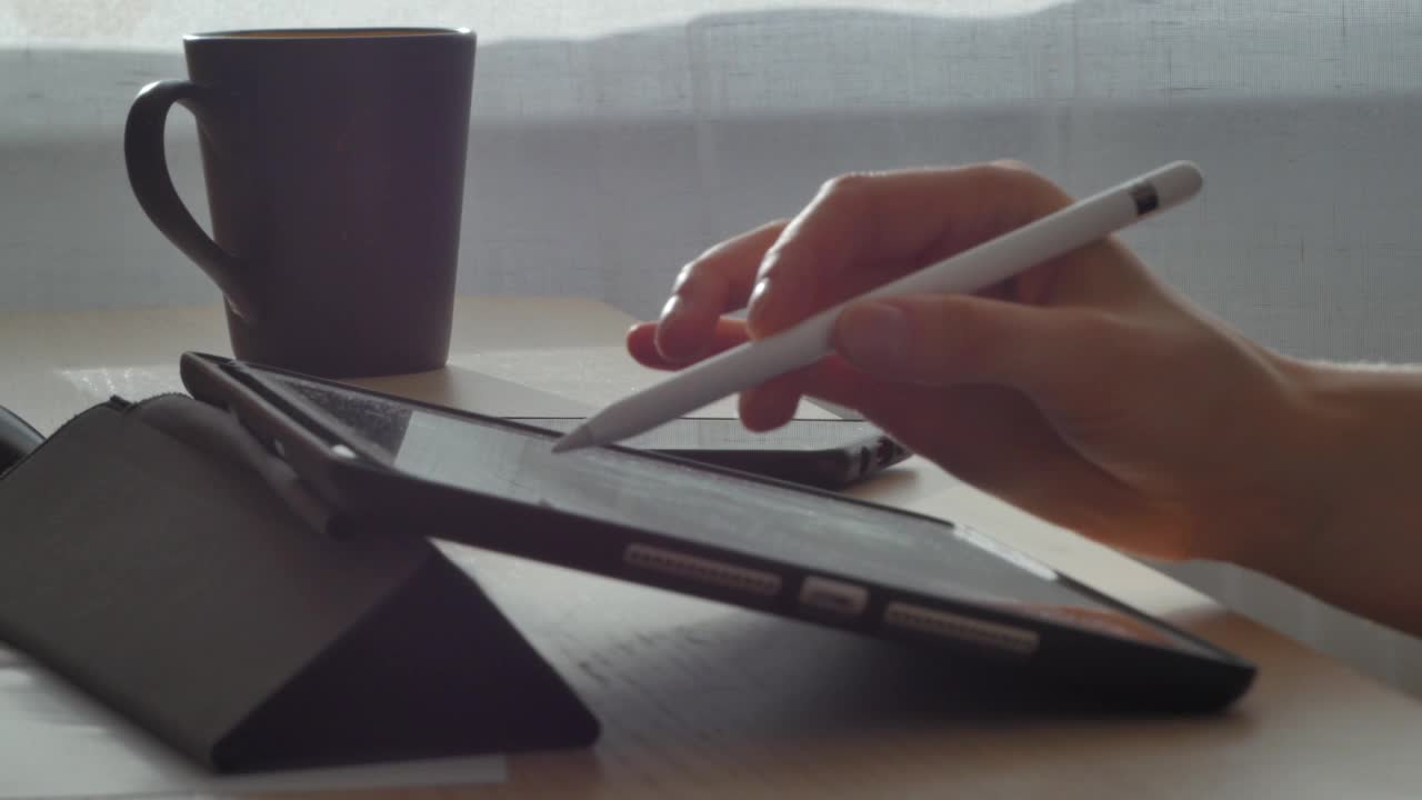一个年轻人在平板电脑上用笔画画视频下载