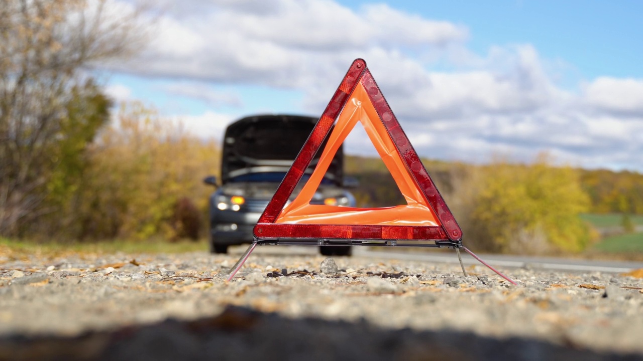 有问题的汽车和红色三角警告其他道路使用者视频下载