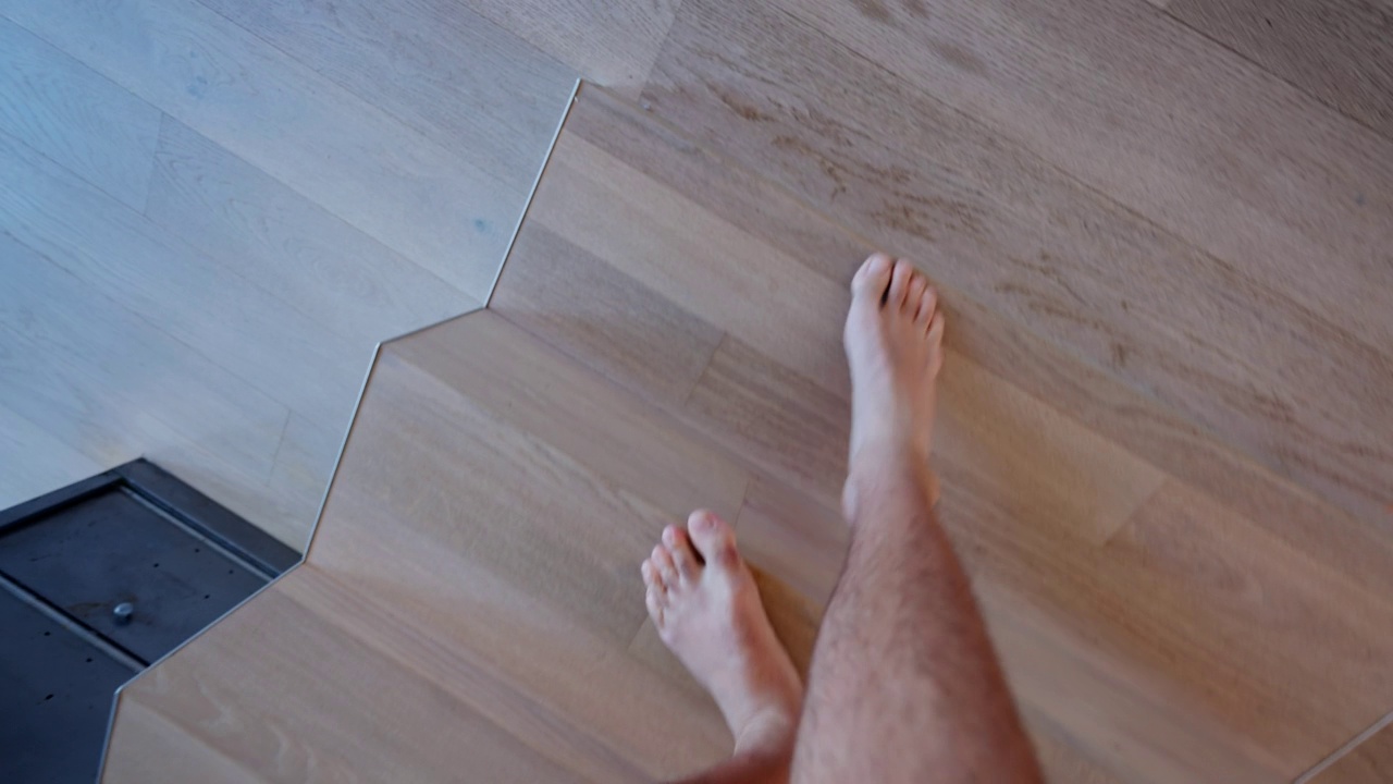 人的腿在家里走路下楼梯。男人脚和脚的观点走在室内视频下载