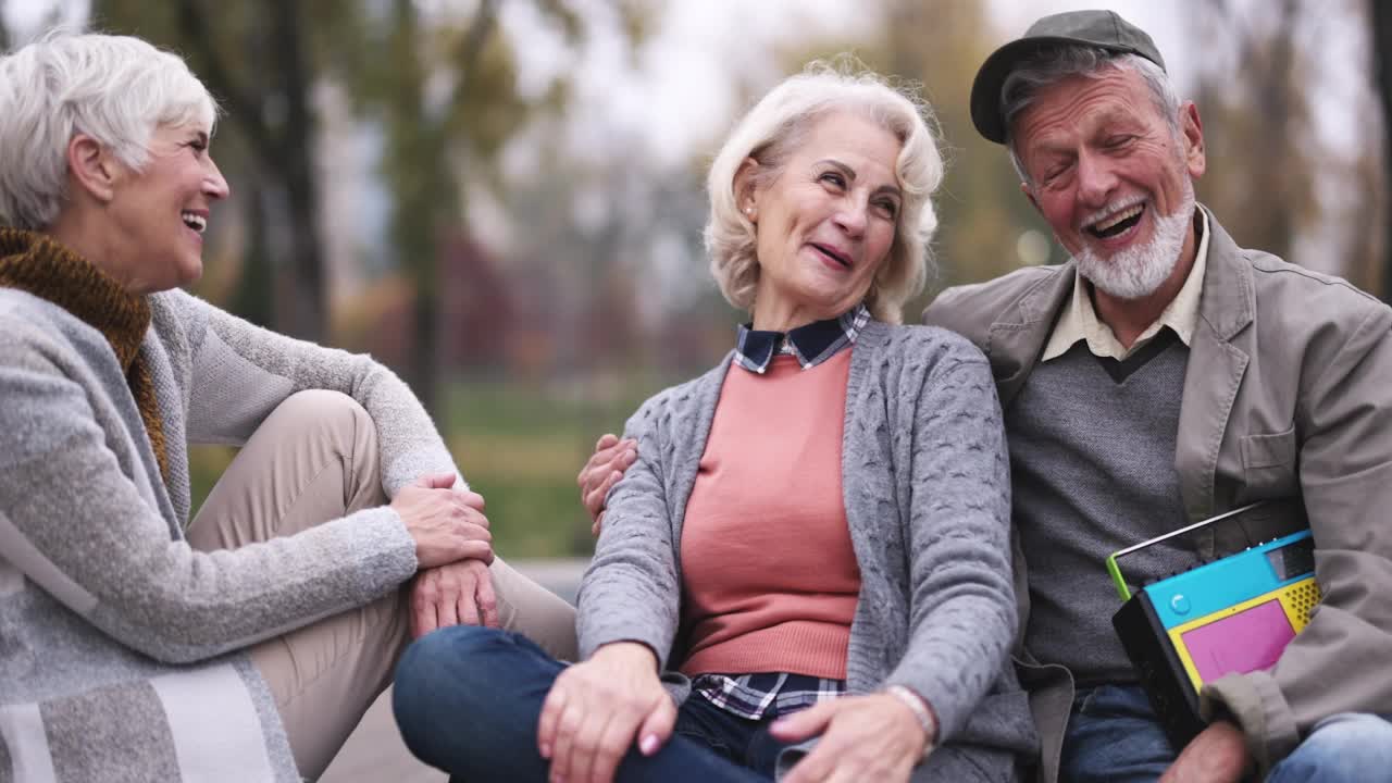 幸福的老夫妇和他们的朋友在公园聊天。视频素材
