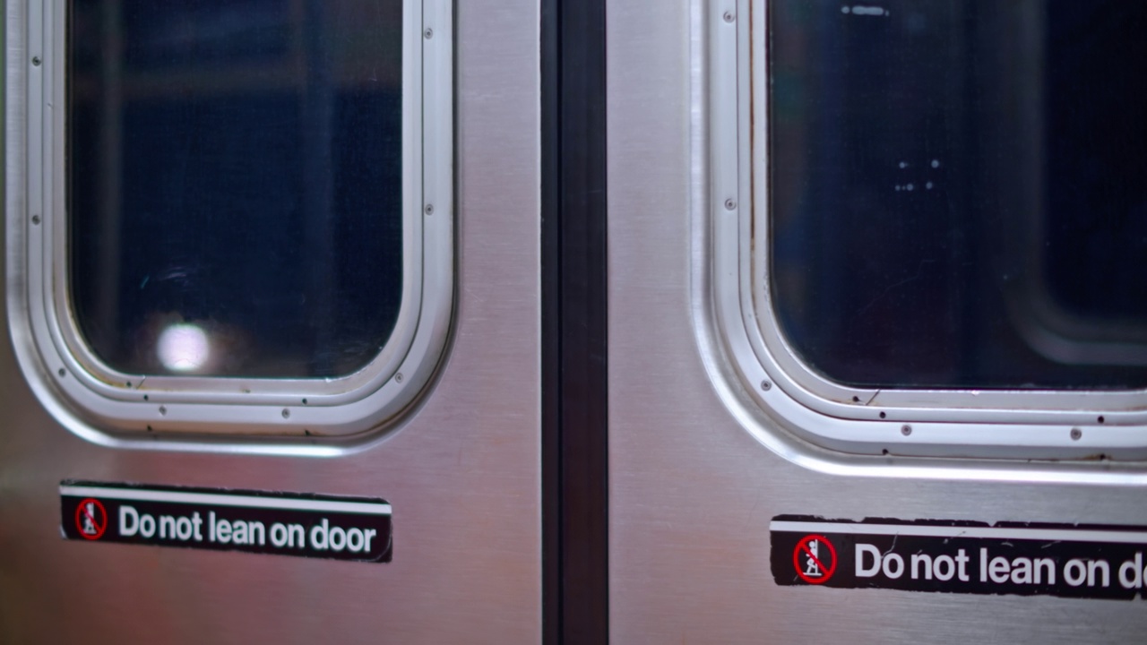 移动中的纽约地铁列车门的手持镜头视频下载