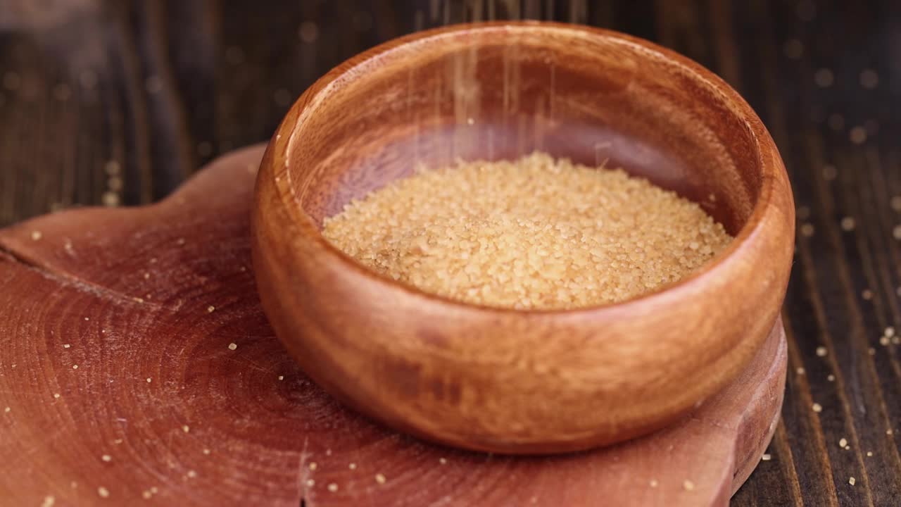 将天然红蔗糖倒入木碗中视频素材