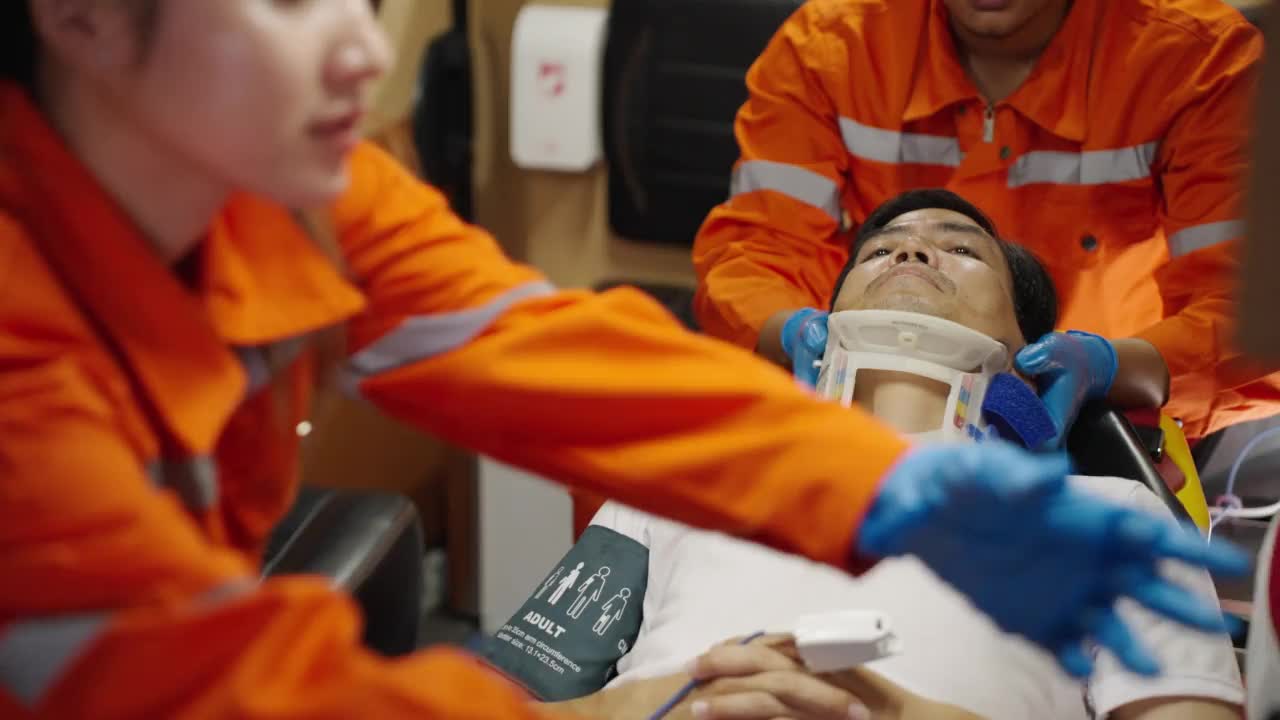 亚洲急救医疗技术员(EMT)或辅助医务人员，在救护车上为病人提供紧急氧气视频下载