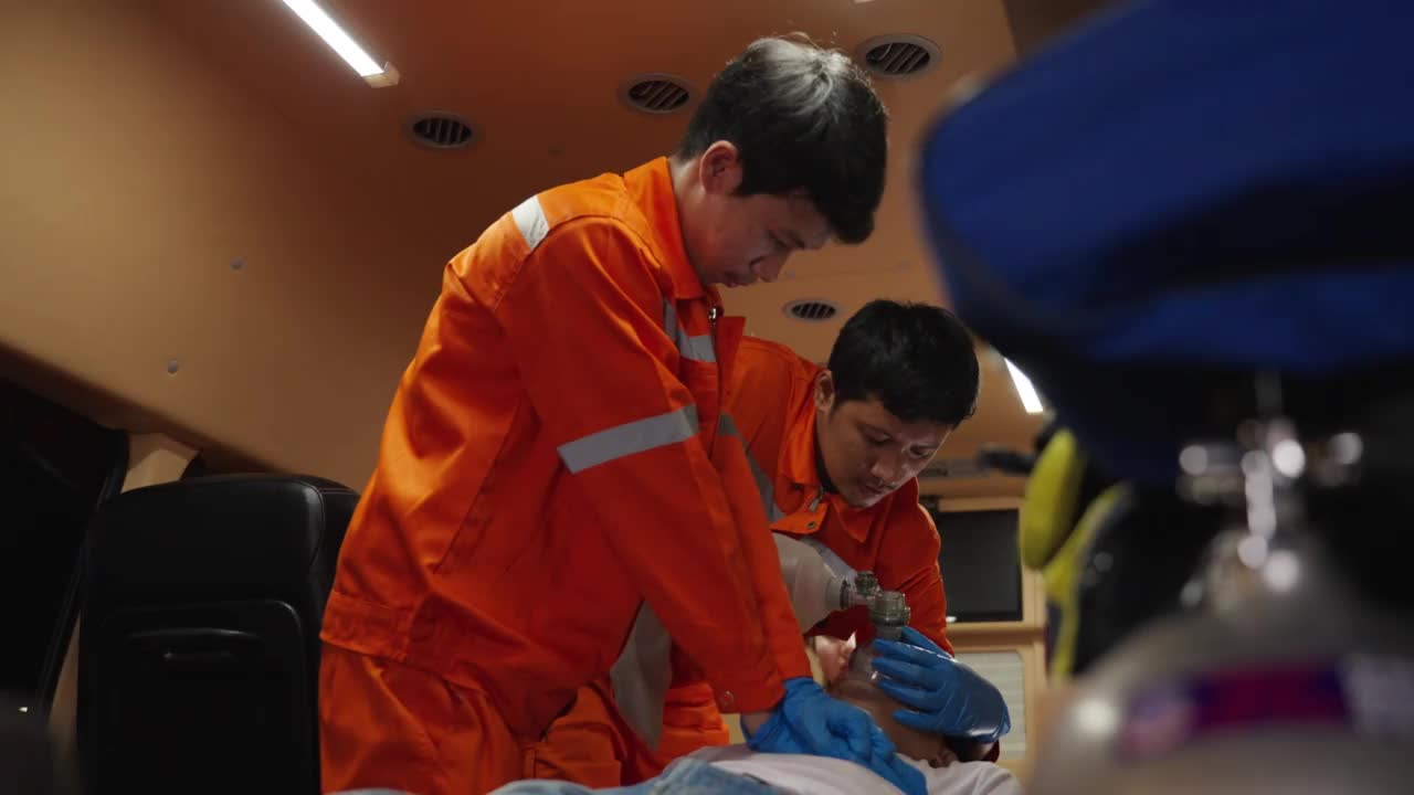 亚洲急救医疗技术人员(EMT)或辅助医疗团队对患者进行心脏泵送心肺复苏，心脏骤停或心肺复苏的概念视频下载