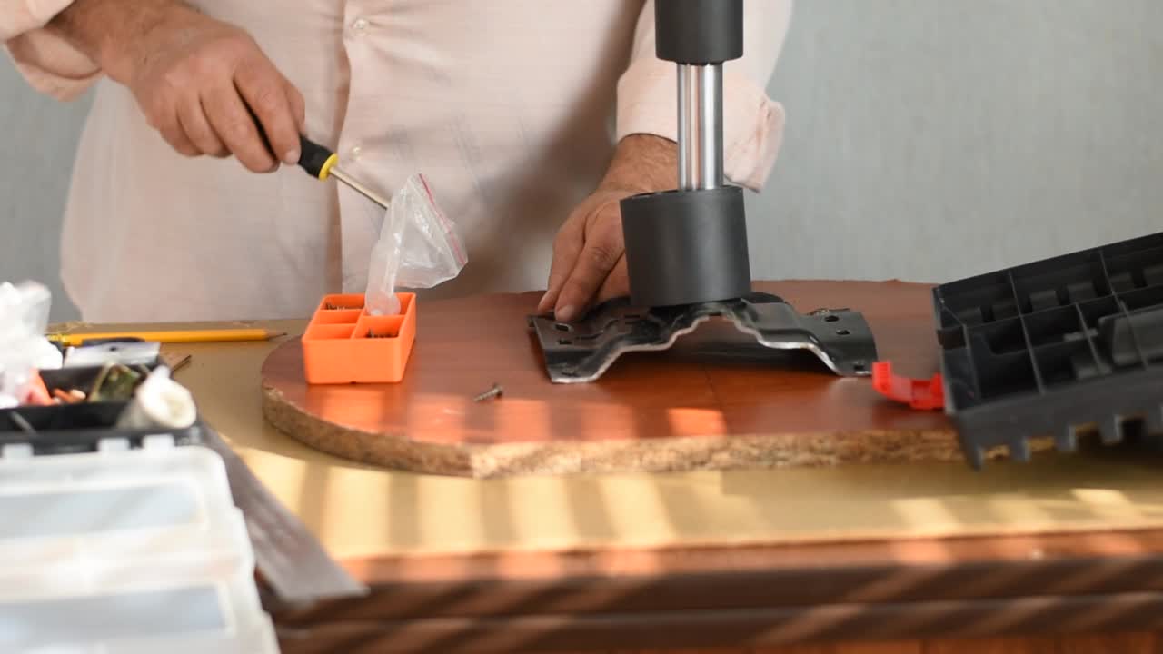木匠用螺丝刀把螺丝拧到木板上。视频素材