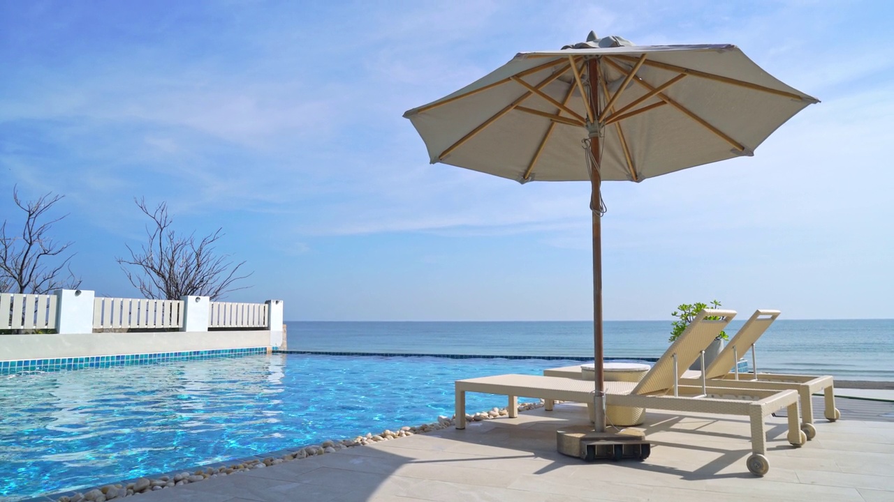 空床池周围的游泳池与大海的背景-假期和度假的概念视频下载