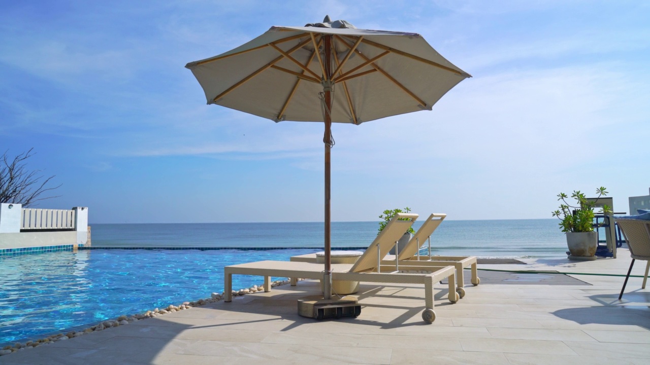 空床池周围的游泳池与大海背景-假期和假期的概念视频下载