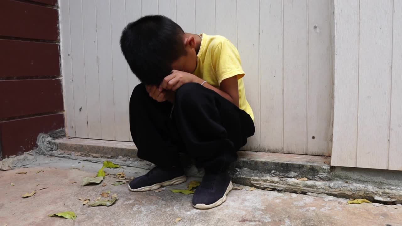 一个无家可归的小男孩坐在公园里视频素材
