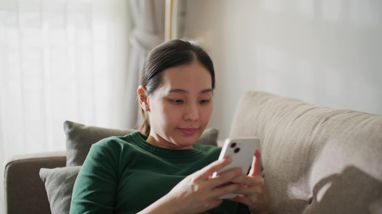 妇女在家里使用智能手机视频素材