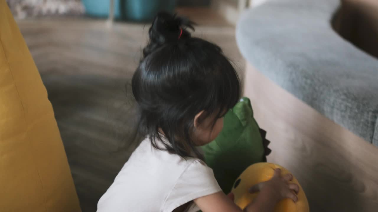 可爱的小女孩，亚洲-白人混合种族的孩子玩毛绒娃娃玩具在家里的客厅，可爱的时刻。儿童成长，儿童趣味教育理念视频下载