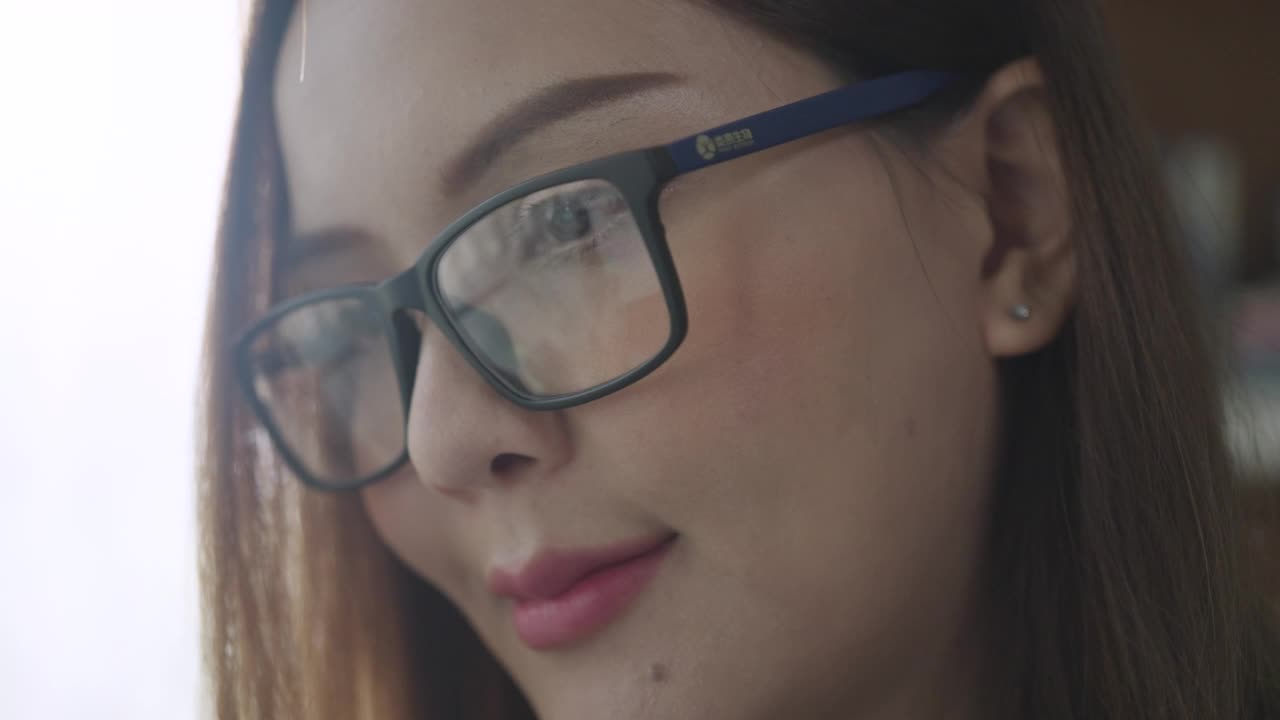 特写女商人的脸戴眼镜在她的办公室工作时间视频素材