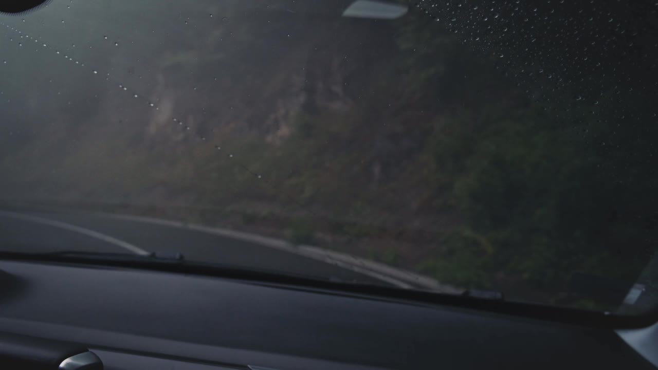 在雨中行驶在蜿蜒的山路上。视频素材