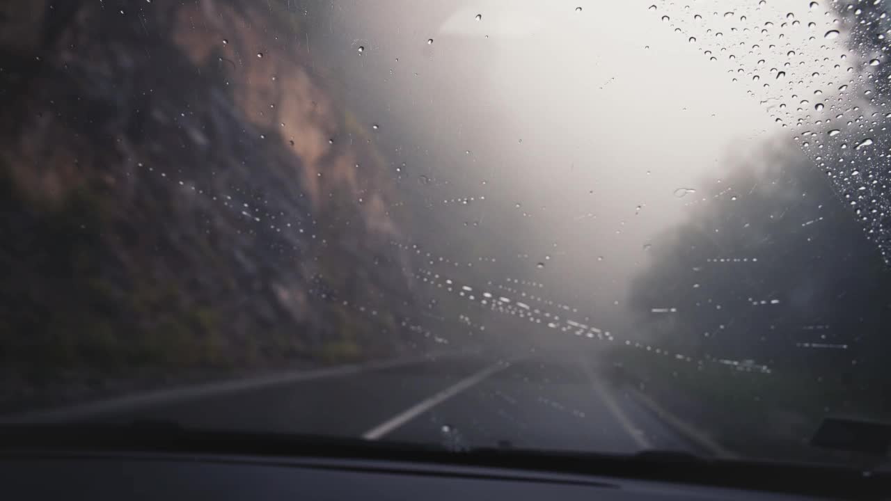 在雨中行驶在蜿蜒的山路上。视频素材