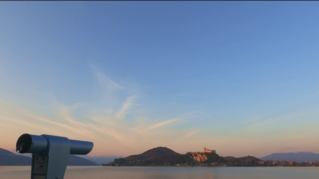 从阿罗那的视角看日落时，望远镜指向意大利马焦雷湖上的安杰拉城堡视频素材