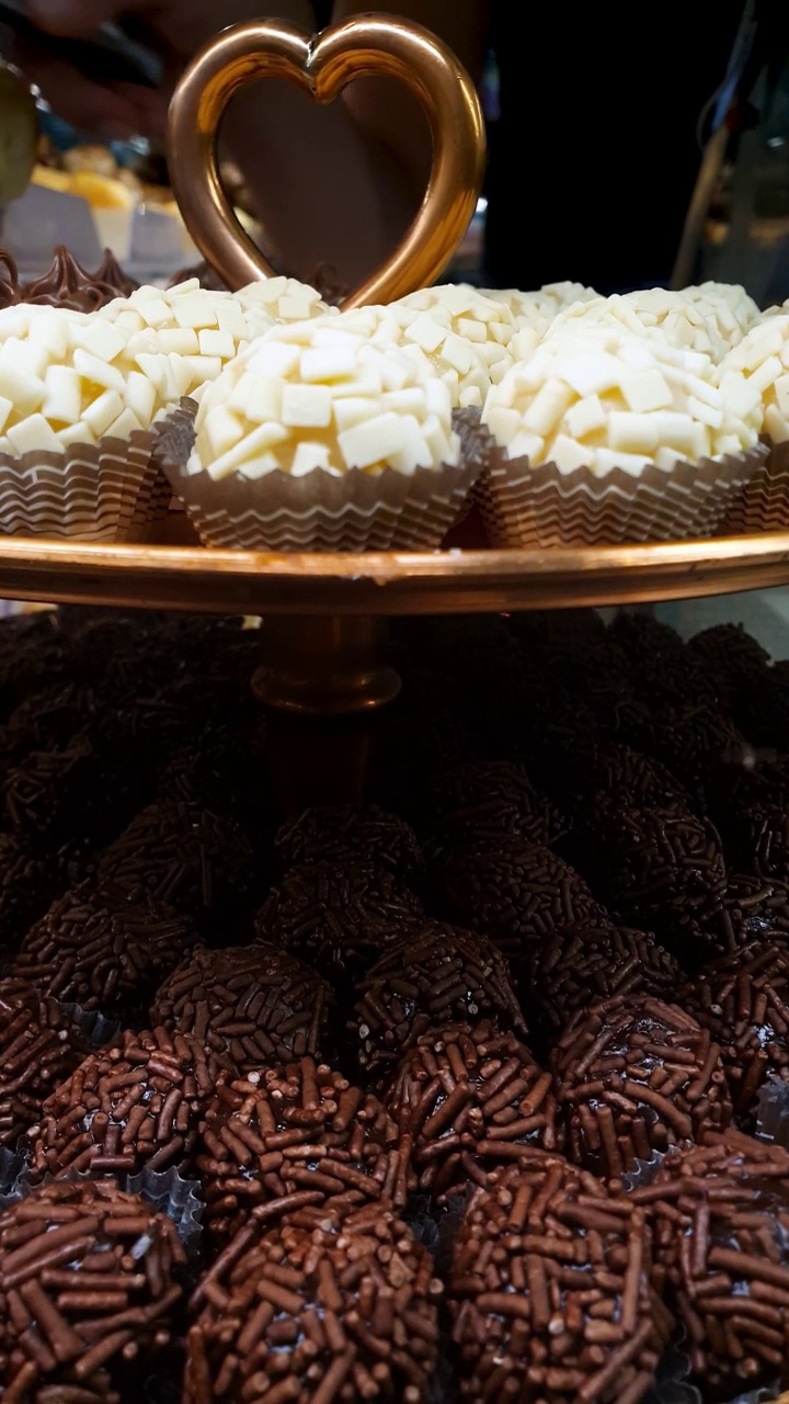 巴西巧克力软糖球堆放在托盘上(传统的，撒有白巧克力)-垂直。视频素材
