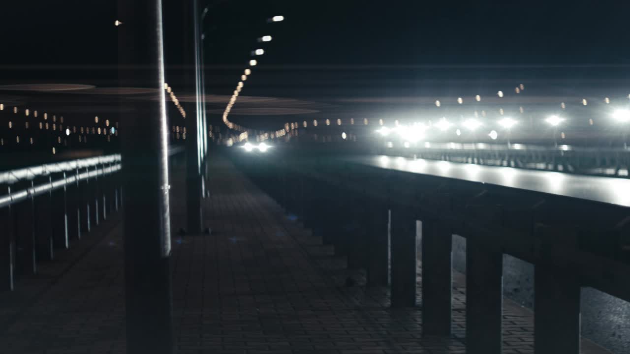 低角度视角的跑车行驶在夜间的道路与相机跟踪视频素材