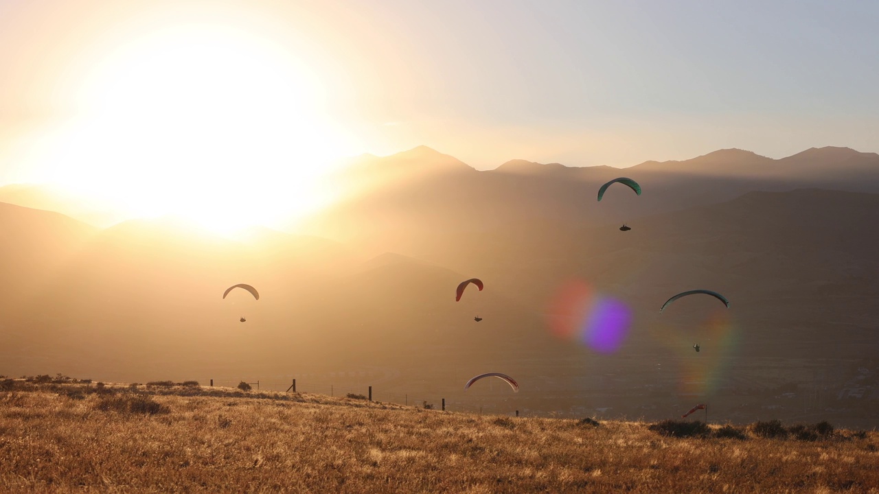 几个滑翔伞的剪影对太阳落山视频下载