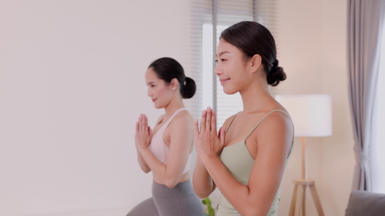 年轻的亚洲夫妇在家学习在线瑜伽课程。视频下载
