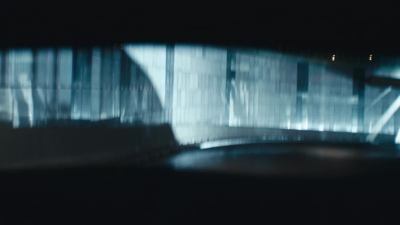 后座乘客POV跑车在夜间通过隧道与司机剪影。强烈的蓝光视频素材